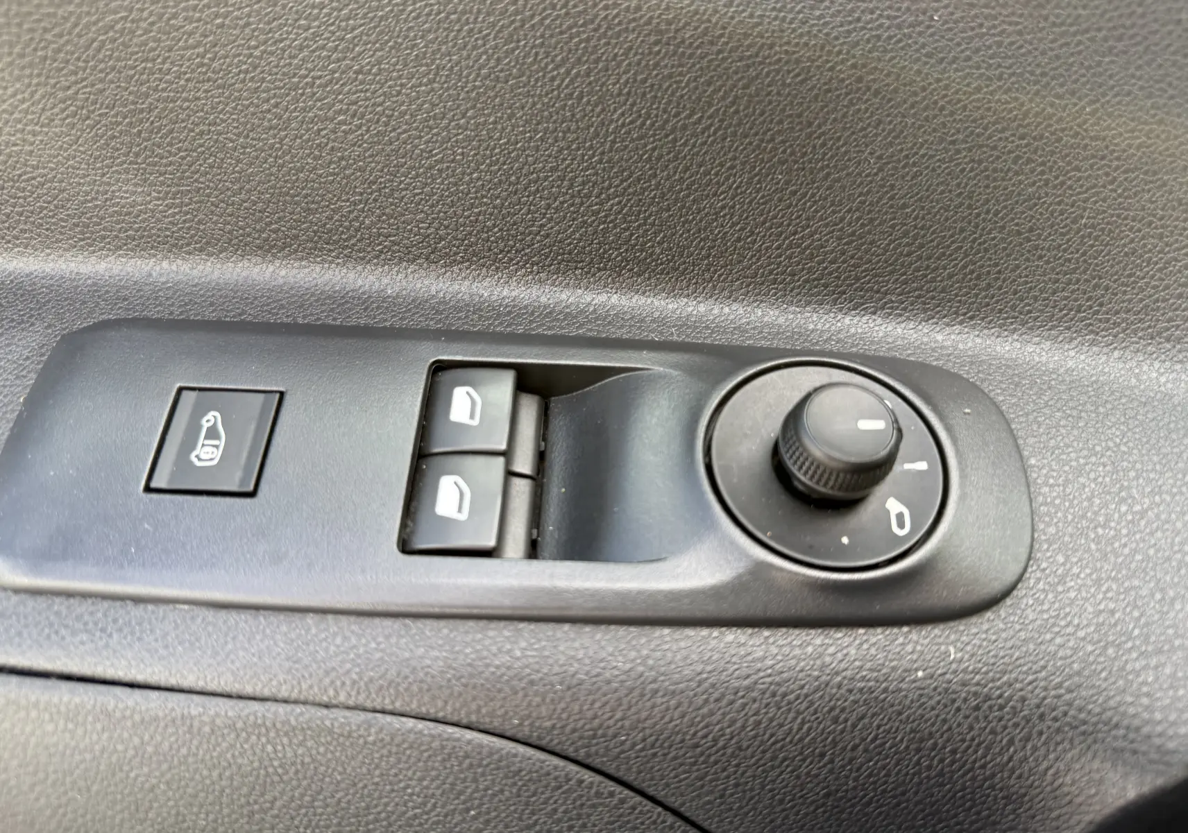 Commande de réglage des rétroviseurs et des vitres électriques sur la porte intérieure d'un Peugeot Partner blanc 2021.