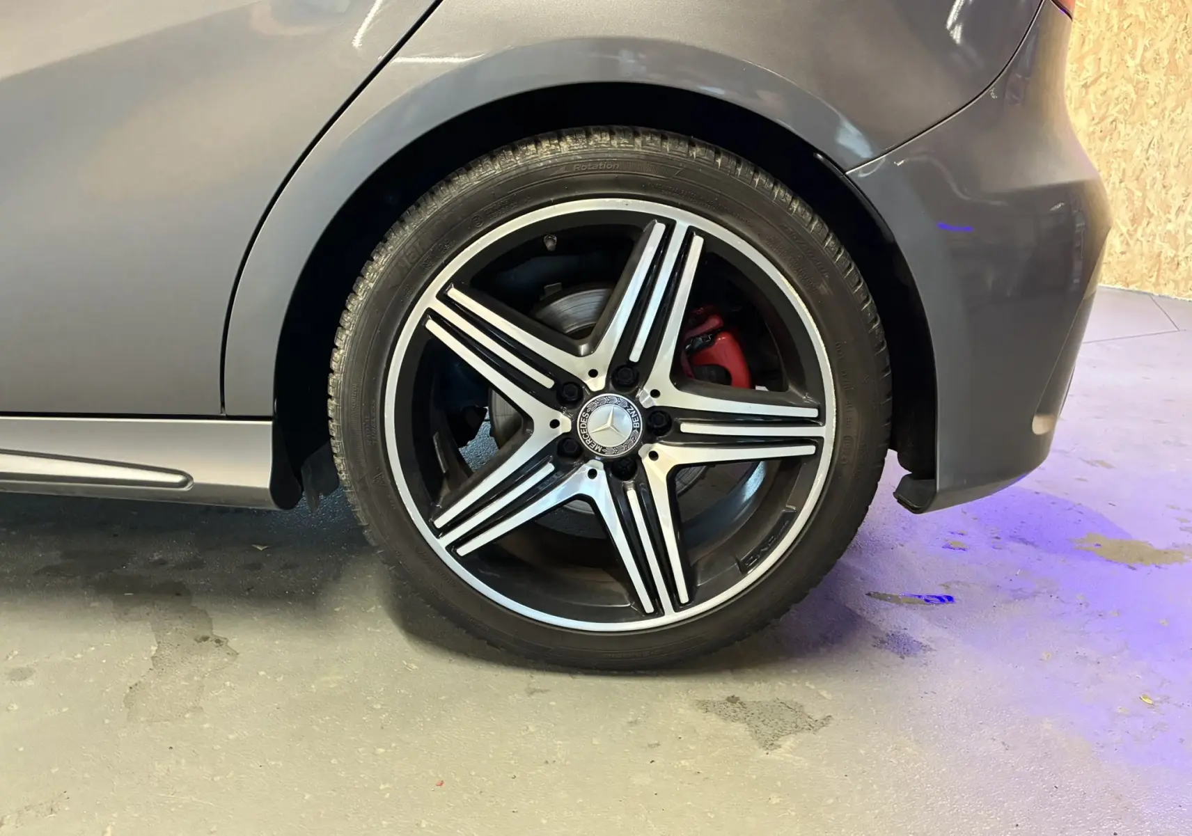 Gros plan sur la roue arrière droite gris métallisé d'une Mercedes Classe A 250 AMG Sport avec jante alliage 5 branches et étrier rouge.