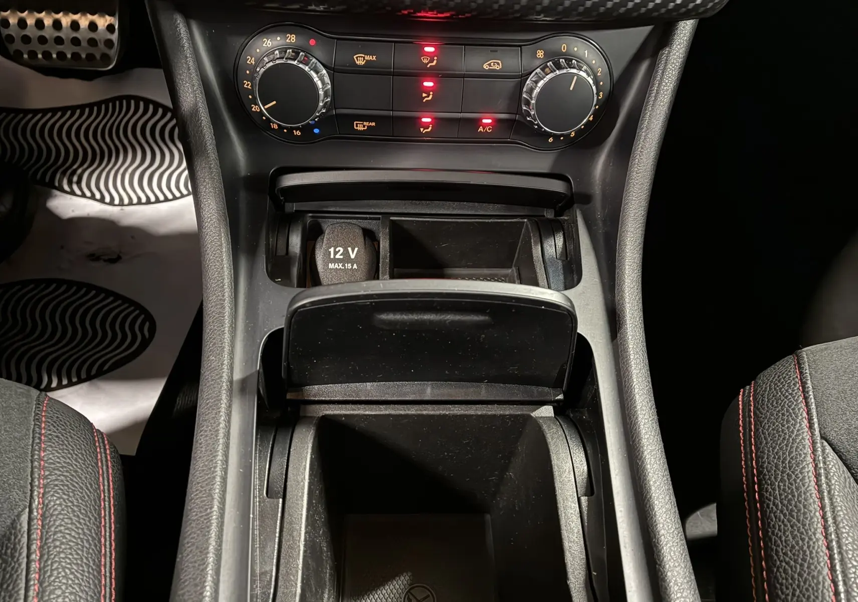 Vue rapprochée de la console centrale intérieure de la Mercedes Classe A 250 AMG Sport 2014 avec commandes climatisation et prise 12V.