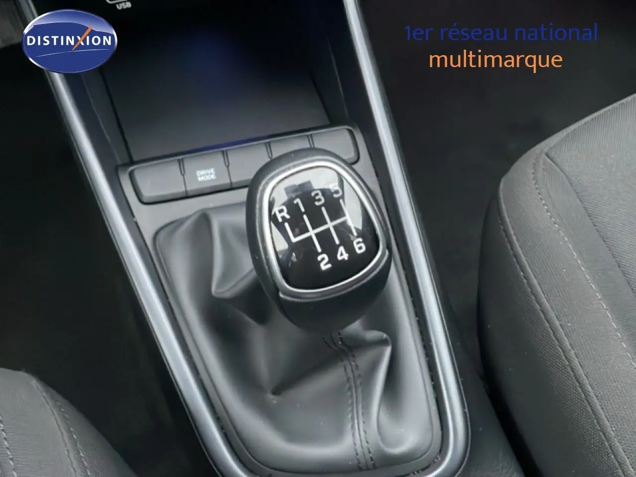 Le levier de vitesses manuel de la Hyundai i20 1.0 TGDI 100CH KLASS, vue rapprochée de la console centrale noire.