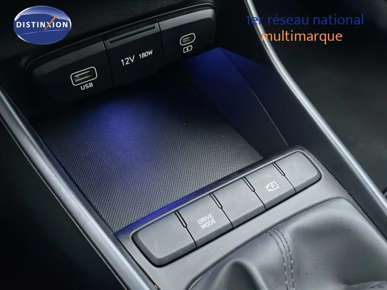 Gros plan sur la console centrale noire avec commandes Drive Mode et prise USB d'une Hyundai i20 Rouge Dragon Metal 2025