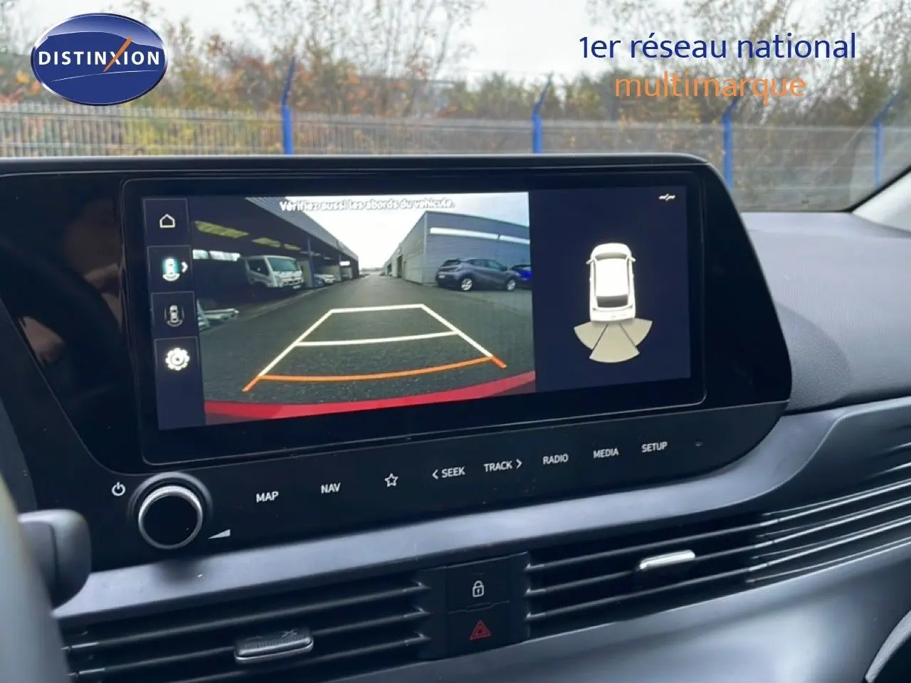Écran central affichant la caméra de recul et les capteurs de stationnement dans l'habitacle d'une Hyundai i20 2025.