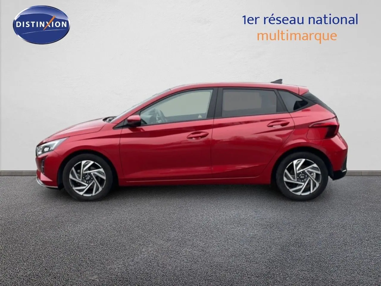 Profil côté gauche d'une Hyundai i20 2025 rouge Dragon Metal avec jantes alliage et lignes dynamiques marquées.