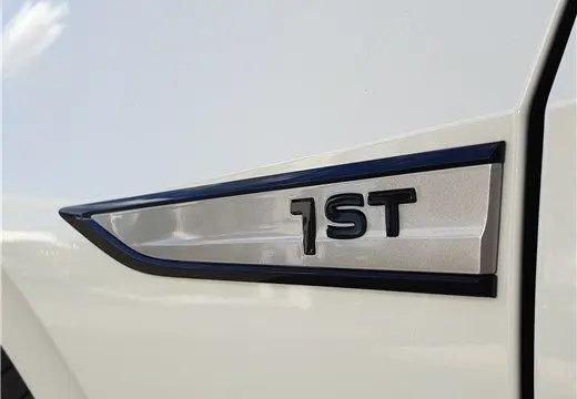 Gros plan sur l'emblème "1ST" noir sur la carrosserie blanc glacier d'une Volkswagen ID.3 électrique 204 ch.