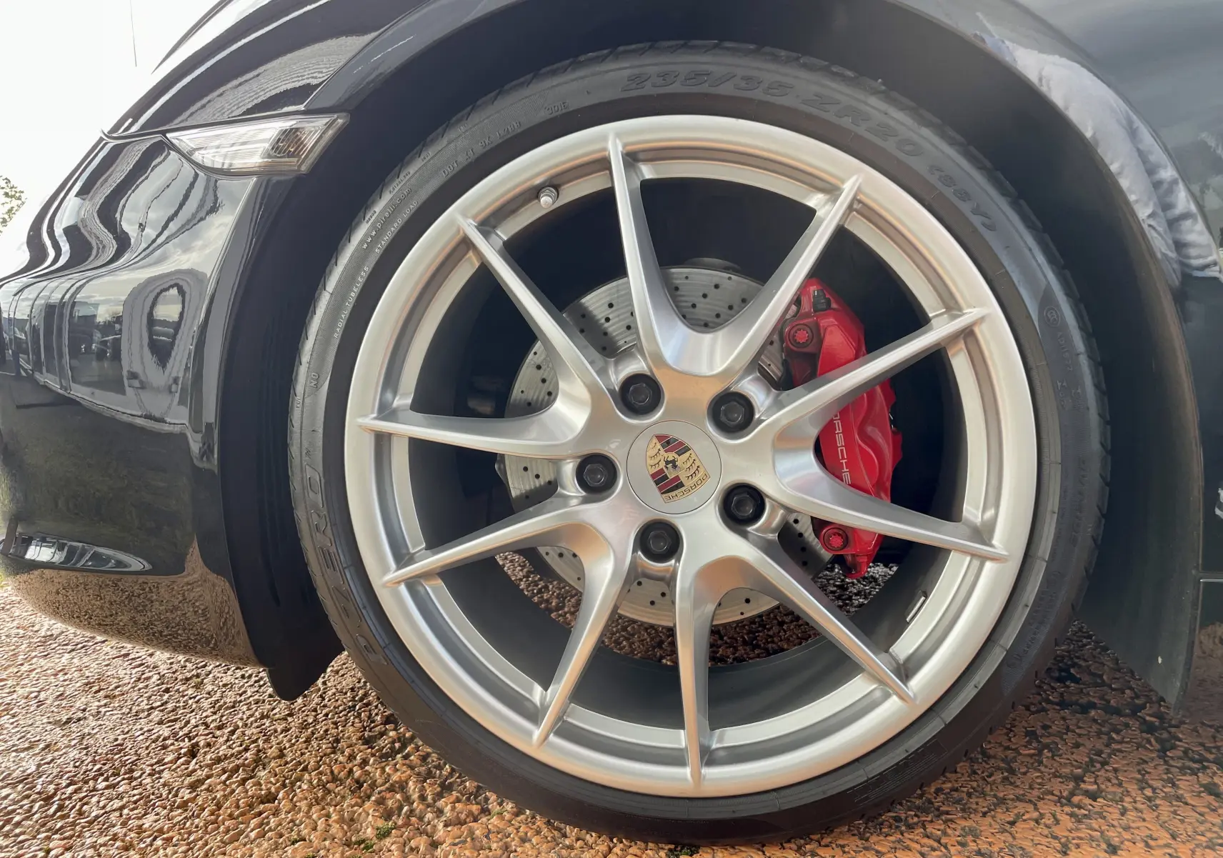 Gros plan sur la jante Carrera S 20 pouces et l'étrier de frein rouge de la Porsche Boxster S noire côté avant droit.