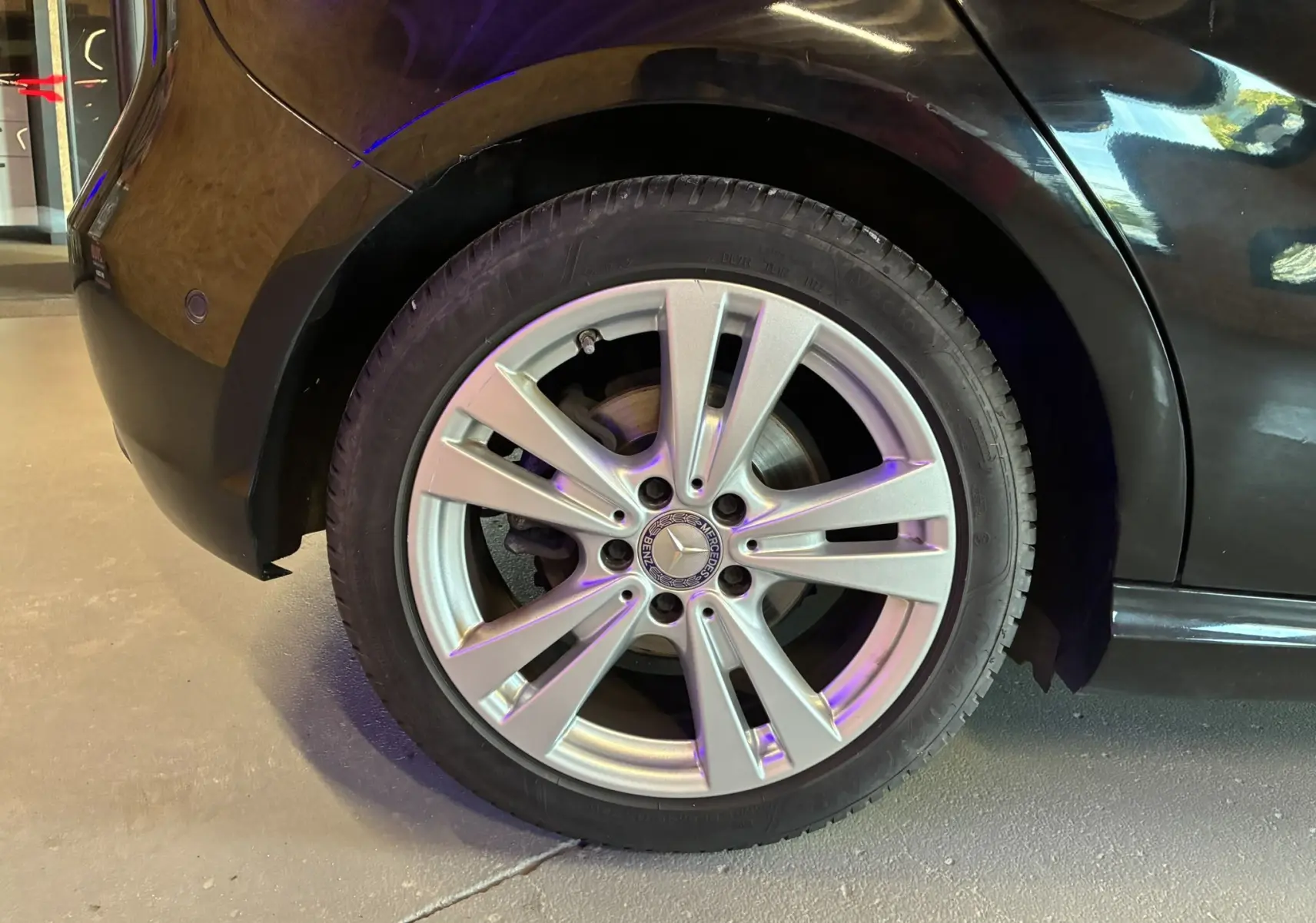 Gros plan sur la roue arrière droite argentée d'une Mercedes Classe A 180 CDI noire, mettant en valeur la jante 17 pouces.