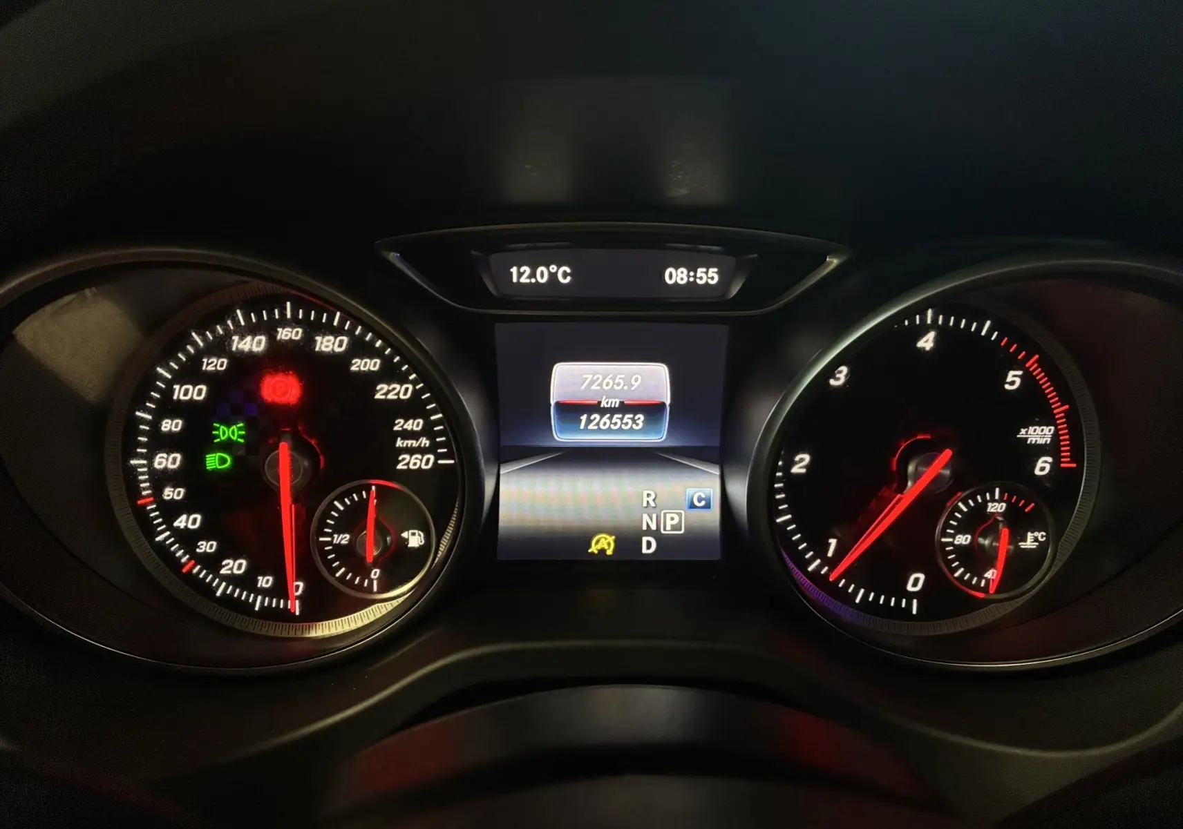 Gros plan sur le tableau de bord numérique d'une Mercedes Classe A 180 CDI noir, affichant vitesse, compte-tours et température.