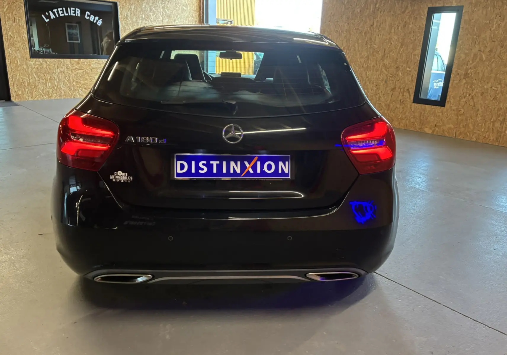 Vue arrière d'une Mercedes Classe A 180 CDI noire de 2018 avec feux arrière allumés dans un garage.