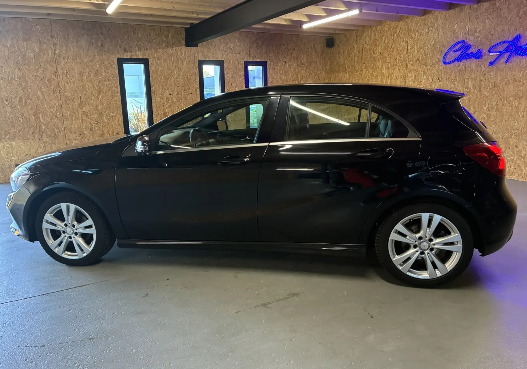 Profil côté gauche d'une Mercedes Classe A 180 CDI Sensation noire, avec jantes alliage et intérieur visible à travers les vitres.