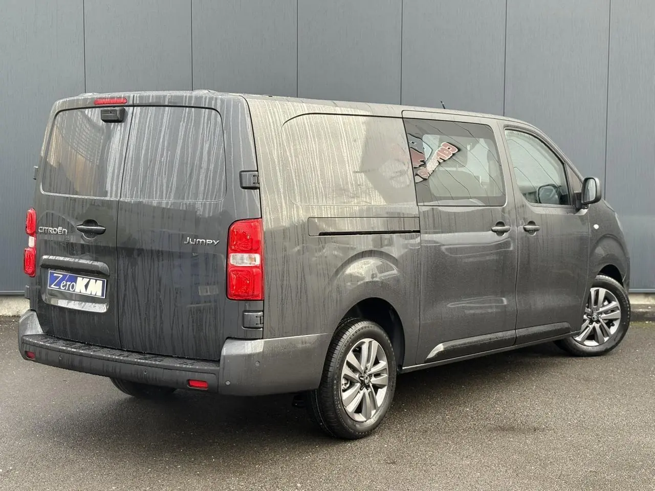 Vue 3/4 arrière droite d'un Citroën Jumpy XL gris titane avec jantes alliage 17'' et portes arrière tôlées.