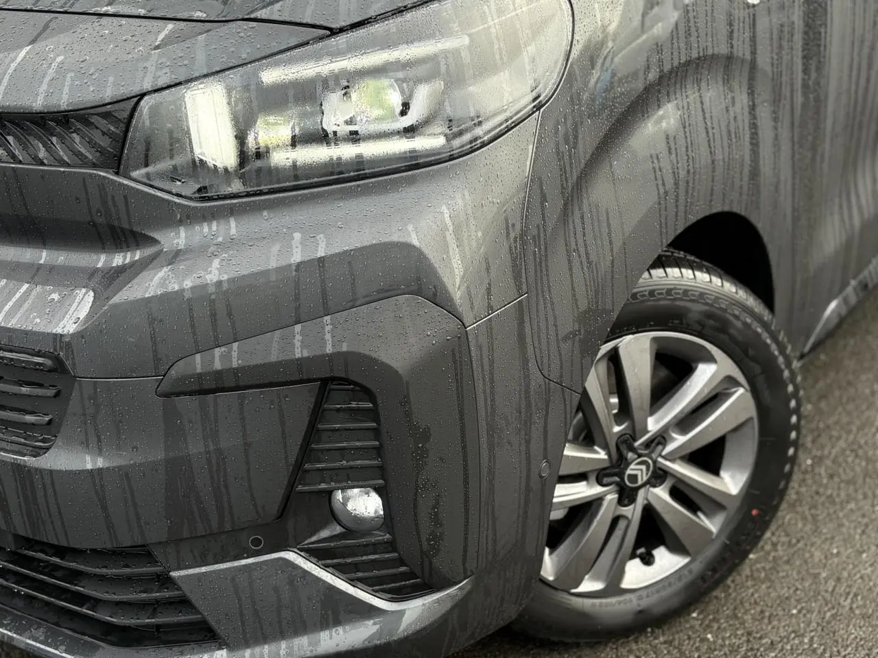Gros plan sur l'avant droit gris titane du Citroën Jumpy XL 2025 avec jante alliage 17'' et phares LED allumés.