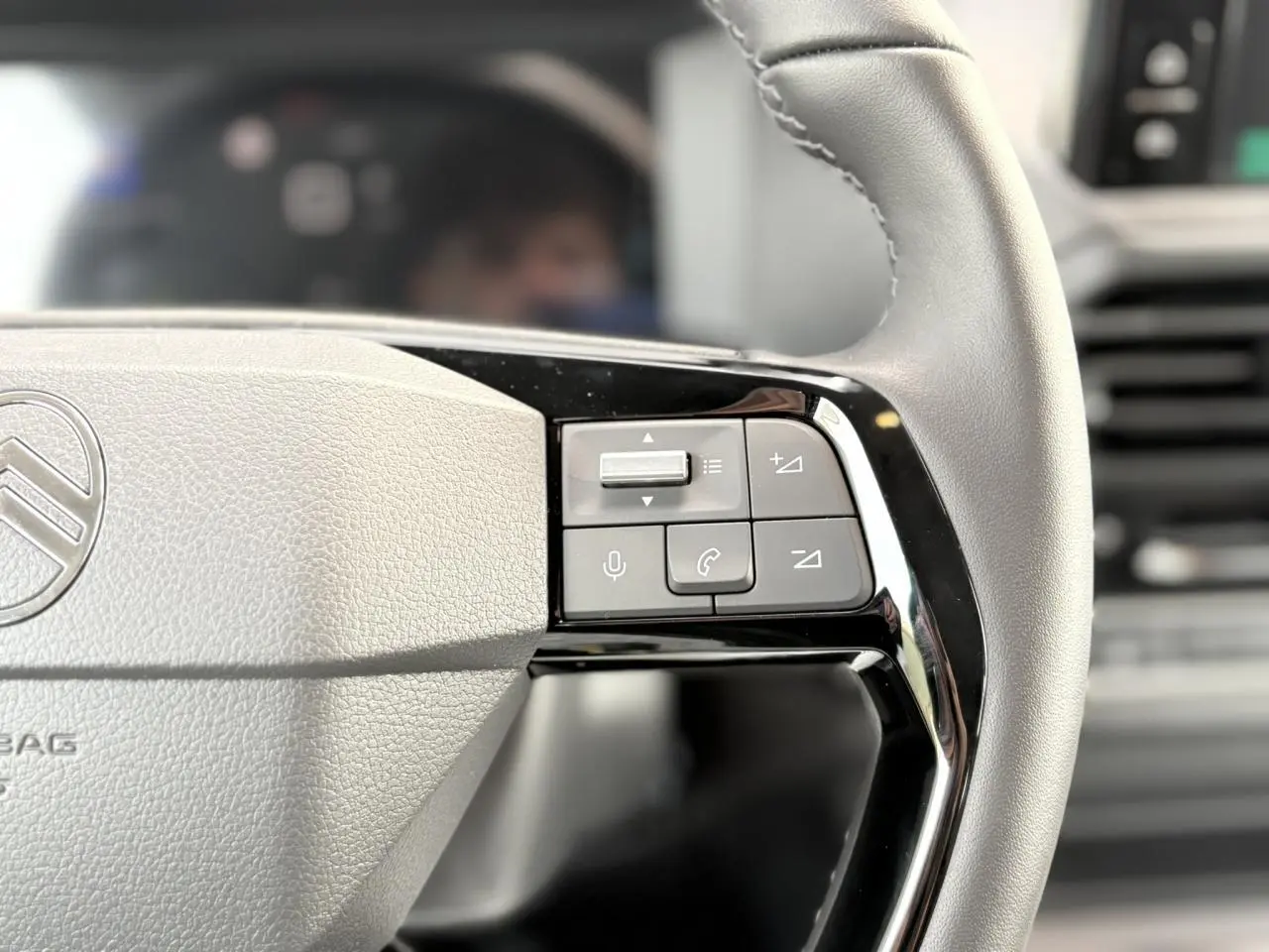 Gros plan sur les commandes du volant cuir gris du Citroën Jumpy XL 2025, avec boutons multifonctions noirs.