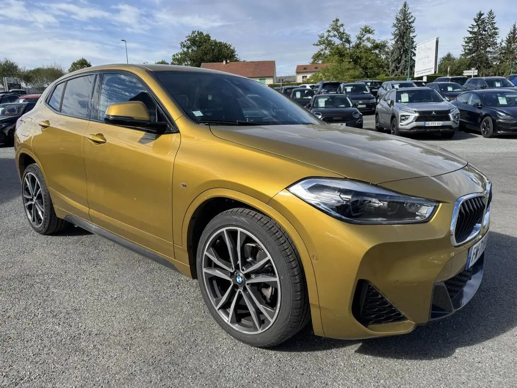 BMW X2 sDrive 18d M Sport jaune métallisé vue 3/4 avant droit avec jantes alliage 19 pouces et toit panoramique.