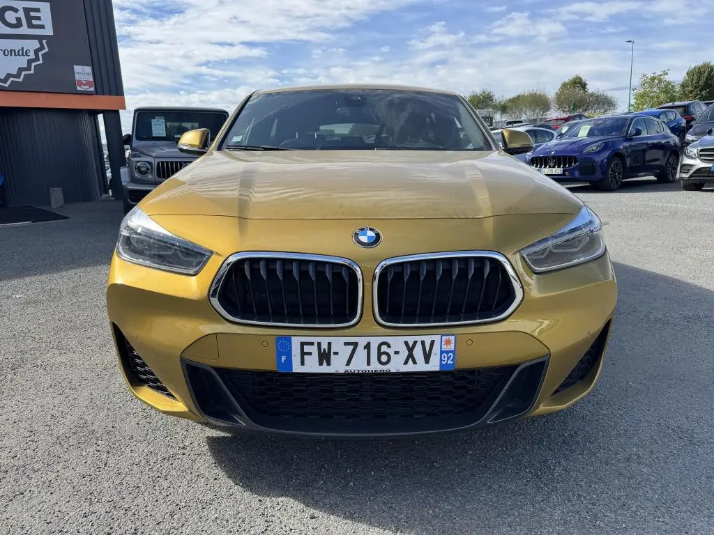 Vue frontale d'une BMW X2 jaune métallisée avec calandre noire et plaques d'immatriculation françaises.