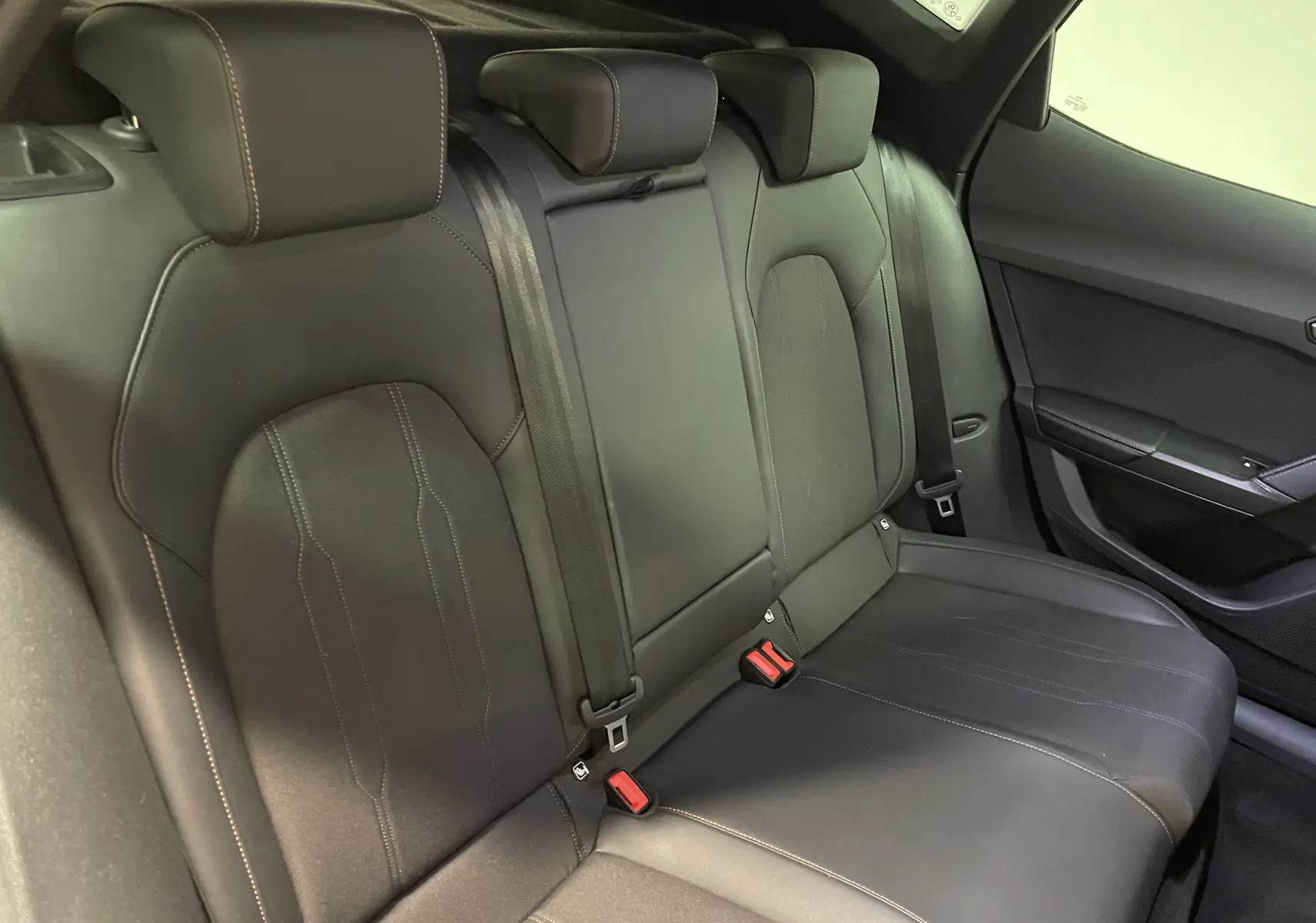 Vue intérieure des sièges arrière en cuir noir du CUPRA Formentor 2025, soulignant les appuie-têtes et ceinture de sécurité.