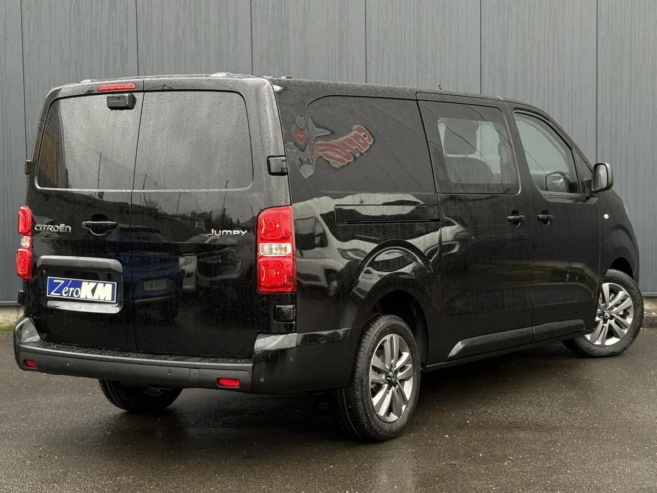 Vue 3/4 arrière droit d’un Citroën Jumpy XL noir Perla avec jantes alliage 17'' grises sous la pluie.