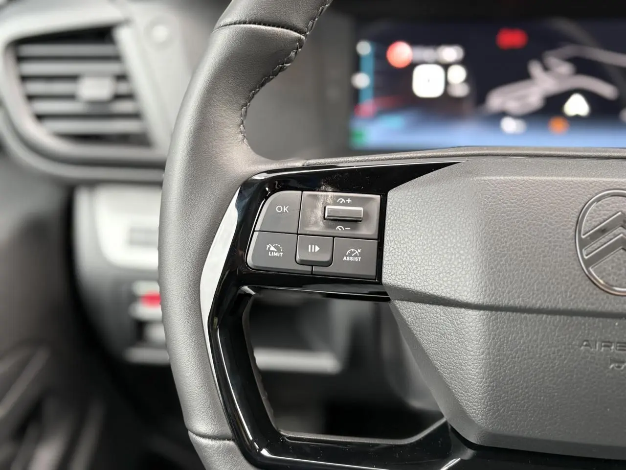 Gros plan sur la partie gauche du volant cuir noir du Citroën Jumpy 2025 avec commandes de régulateur et assistant de conduite.