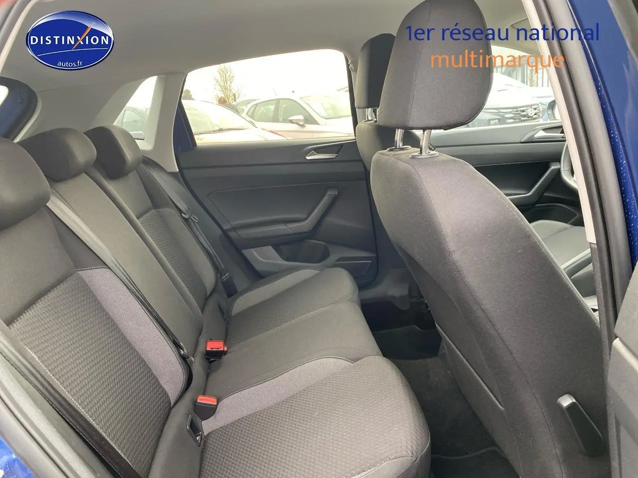 Vue intérieure côté arrière droit de la Volkswagen Polo 1.0 TSI 95 VW Edition bleu récif, montrant les sièges arrière en tissu noir.