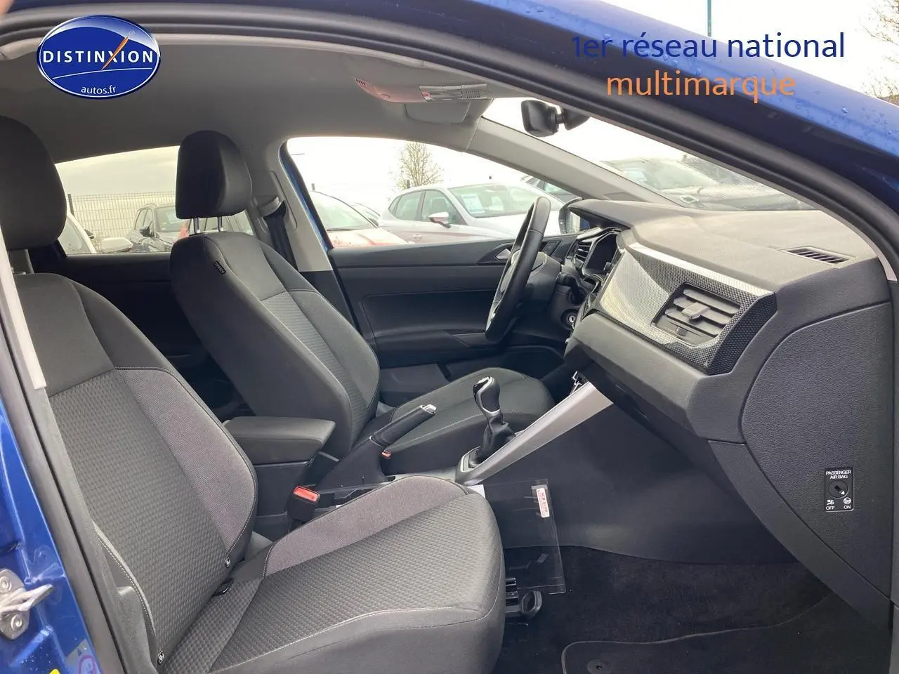 Intérieur avant de la Volkswagen Polo bleu récif, vue côté droit montrant sièges tissu noir et tableau de bord moderne.