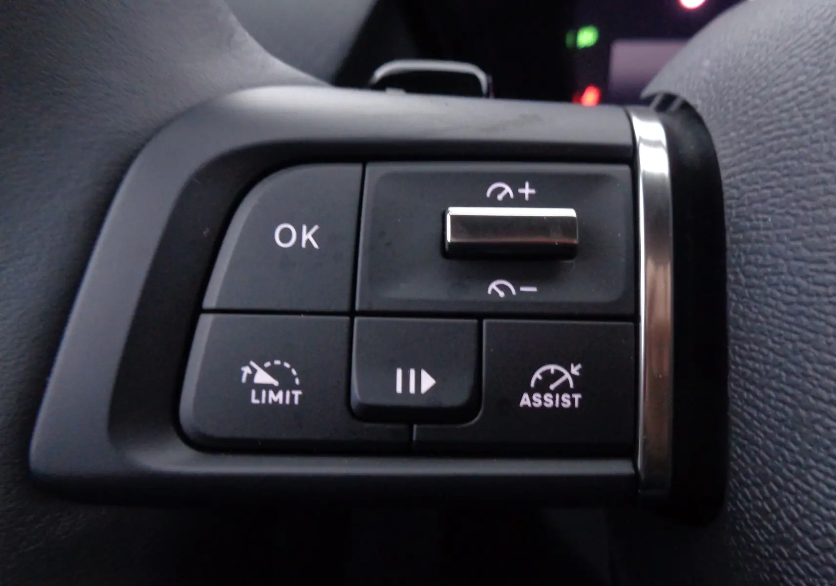 Gros plan sur les commandes au volant côté gauche d'une Citroën C5 X noire, avec boutons de régulateur et limiteur de vitesse.