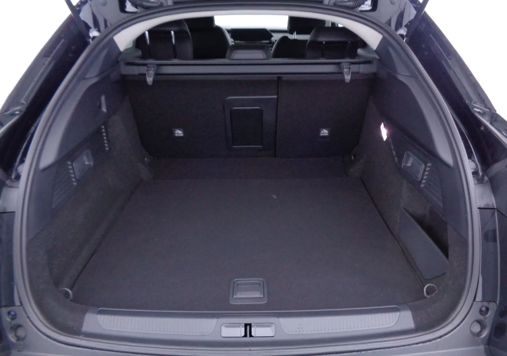 Coffre ouvert vu de l'arrière d'une Citroën C5 X noir métal, montrant un espace de chargement spacieux et bien fini.