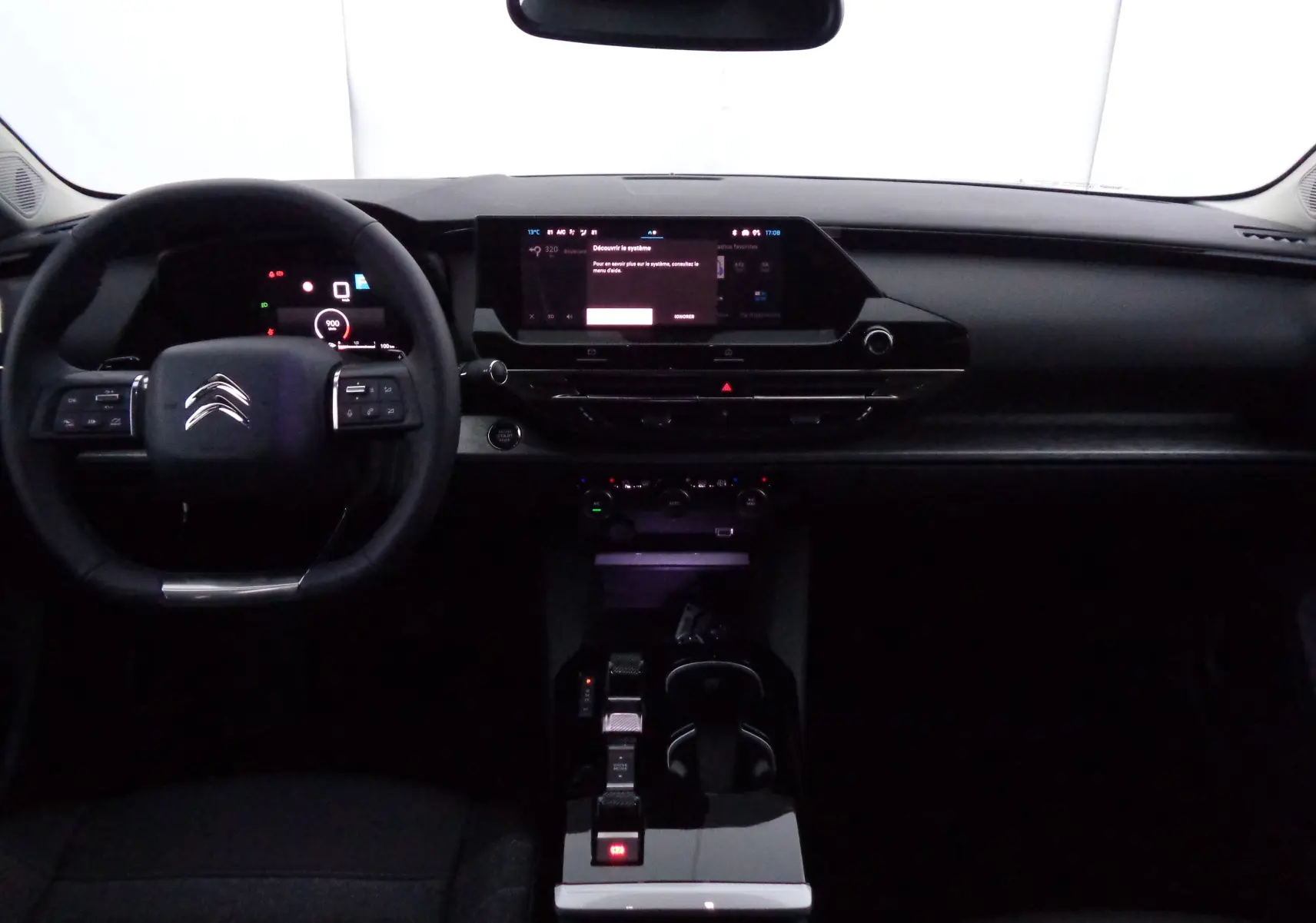 Tableau de bord et volant noir de la Citroën C5 X 2023, vue frontale mettant en valeur l'écran tactile central et commandes modernes.