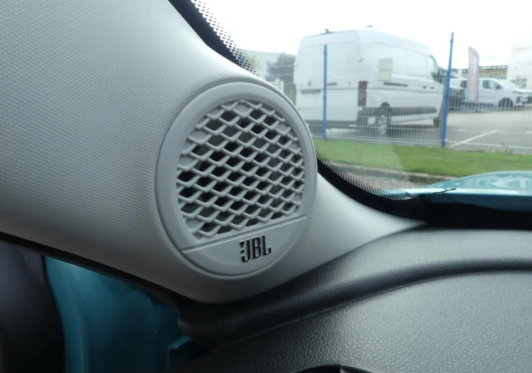 Gros plan sur le haut-parleur JBL côté gauche du tableau de bord d'une Jeep Avenger bleu métallisé 2024.