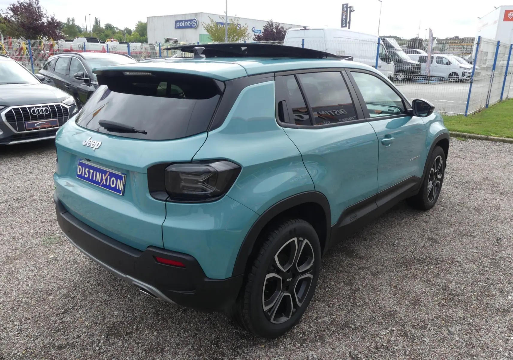 Vue 3/4 arrière droite d'un Jeep Avenger bleu métallisé avec vitres surteintées et jantes alliage 18 pouces.