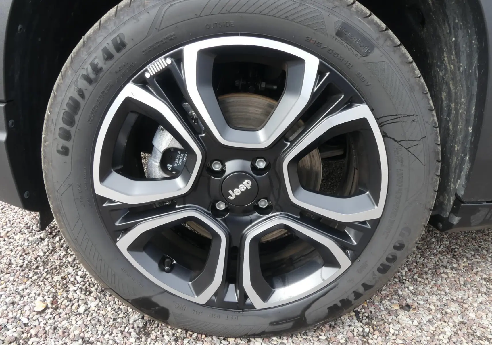 Gros plan sur la jante alliage noire et argentée avec logo Jeep du Jeep Avenger bleu métallisé 2024.