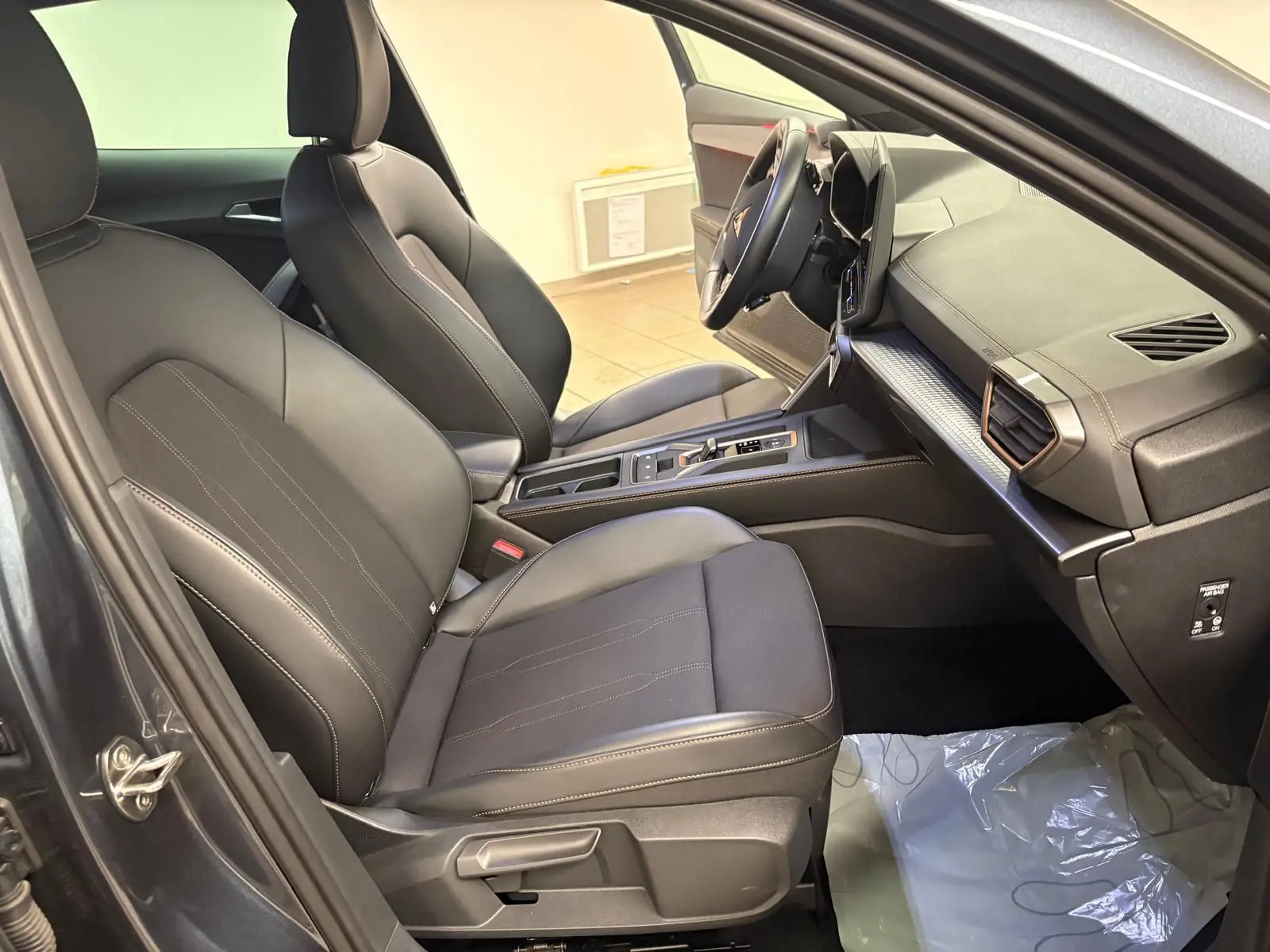 Vue intérieure côté conducteur du CUPRA Formentor gris magnétique, avec sièges en cuir noir et tableau de bord moderne.