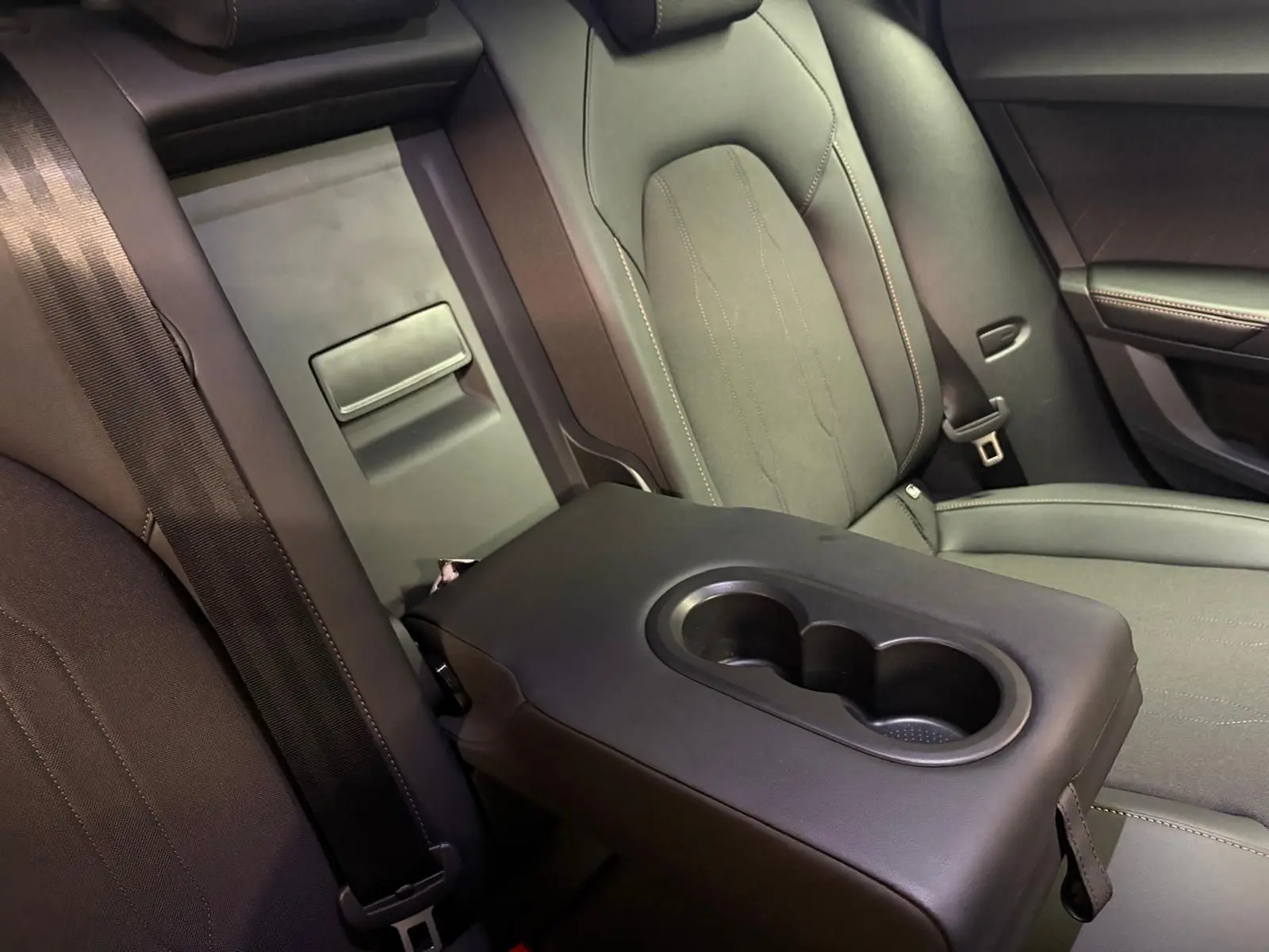 Accoudoir central arrière avec porte-gobelets dans l'habitacle sombre d'un CUPRA Formentor 2025.