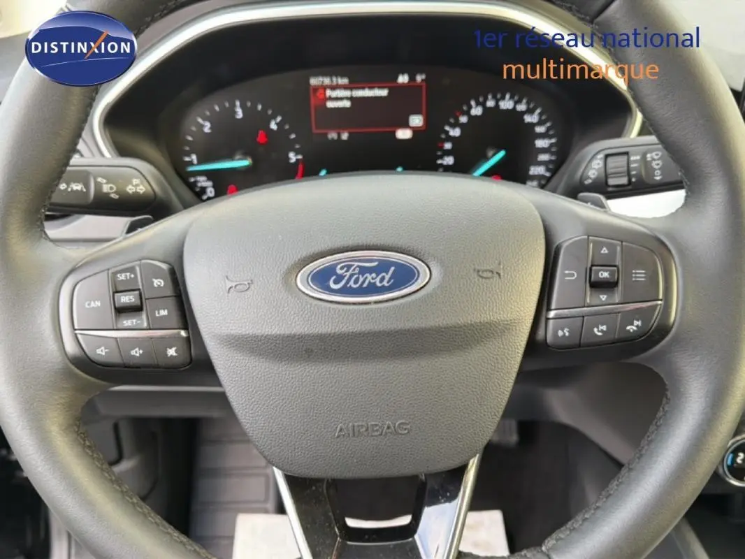 Volant Ford Focus SW 2019 en gros plan, avec commandes intégrées et tableau de bord numérique visible en arrière-plan.