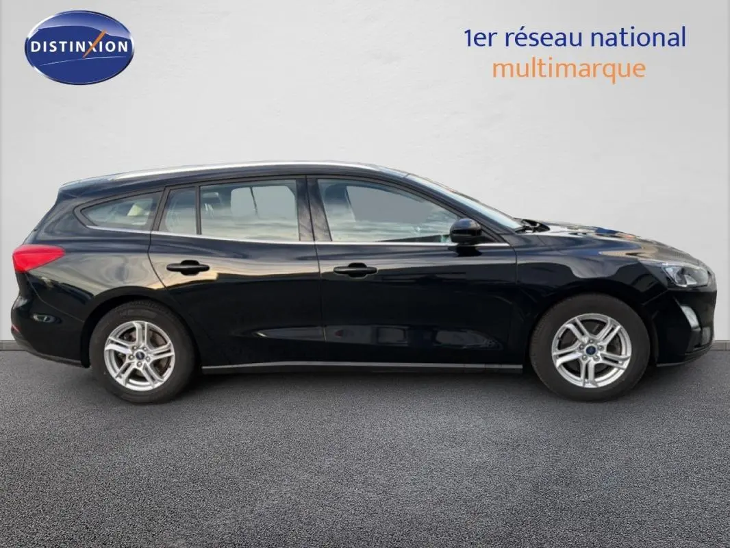 Profil côté gauche d'une Ford Focus SW noire 2019 avec jantes alliage 16 pouces et barres de toit visibles.