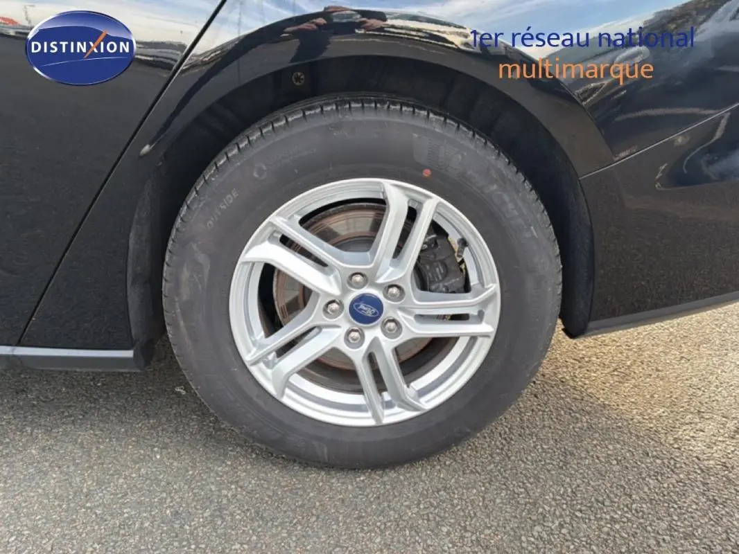 Gros plan sur la roue avant gauche en alliage argenté d'une Ford Focus SW noire de 2019.