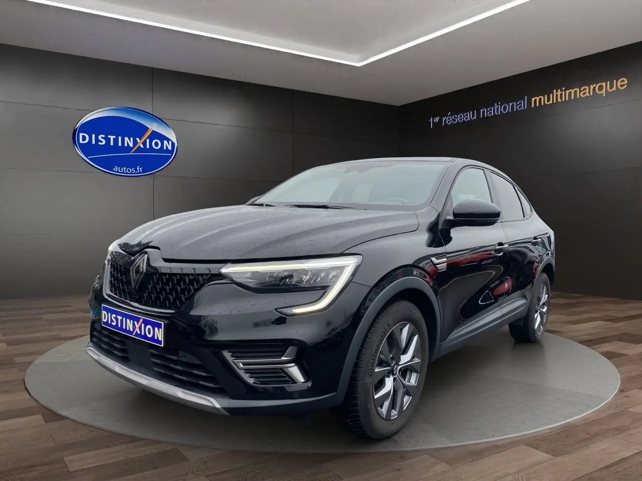 Renault Arkana noir vue 3/4 avant droit en intérieur, avec calandre distinctive et feux LED allumés.