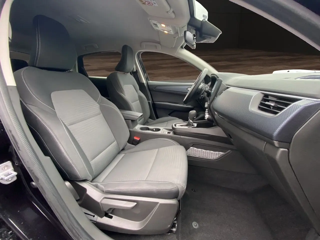 Intérieur avant du Renault Arkana 2024 noir, vue côté gauche montrant sièges et console centrale avec boîte auto.