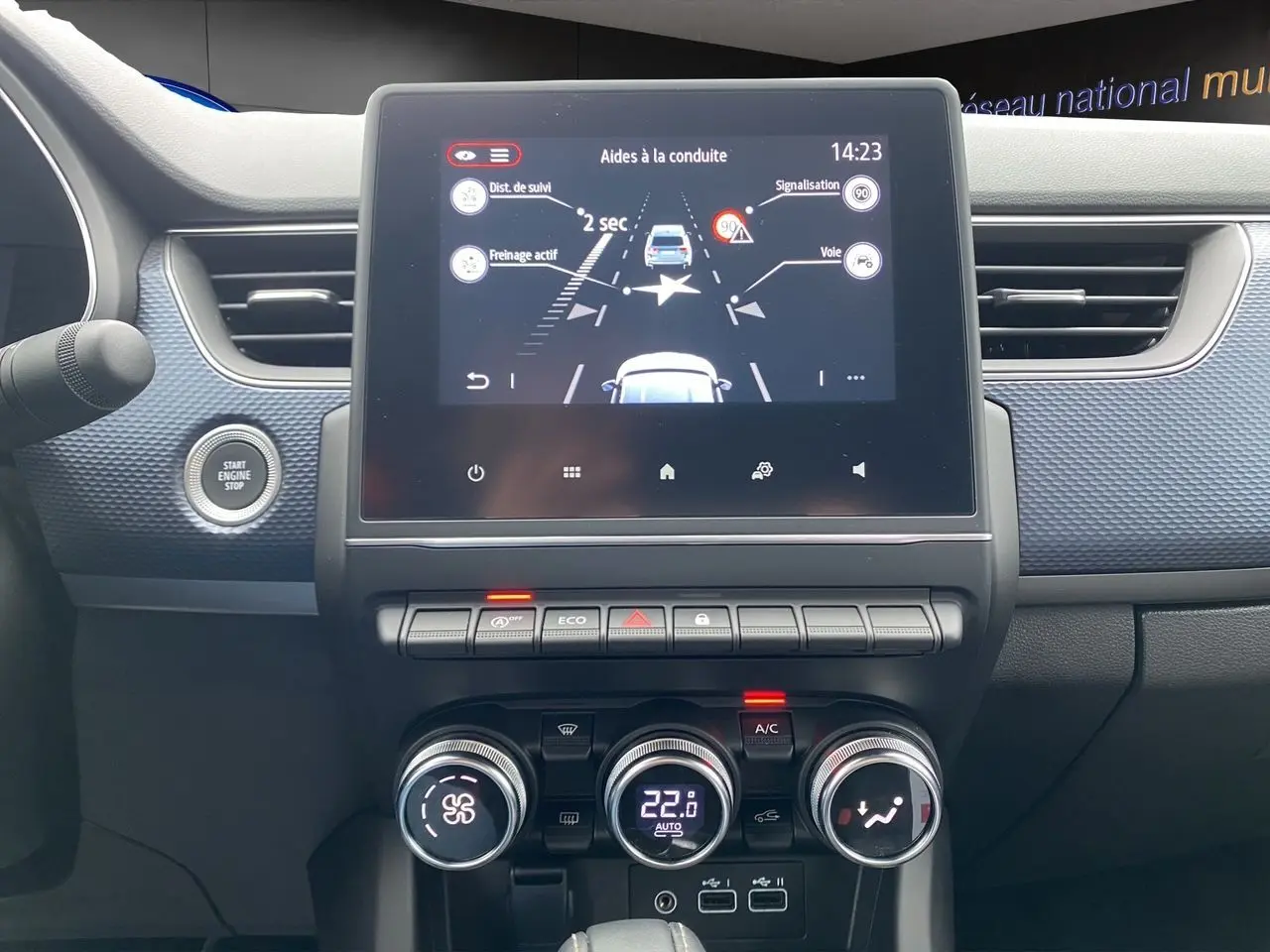 Tableau de bord du Renault Arkana 2024 noir, vue frontale centrée sur l’écran tactile et commandes de climatisation.