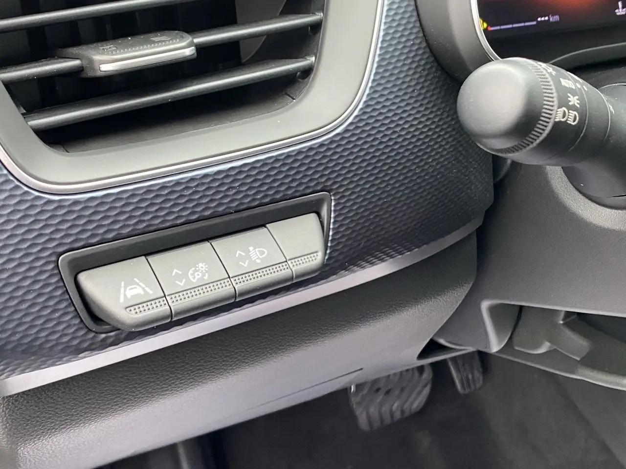 Détail des commandes d’aide à la conduite sur la partie gauche du tableau de bord du Renault Arkana noir 2024.