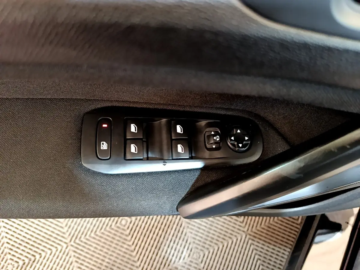 Panneau de commandes des vitres et rétroviseurs côté conducteur d’une Peugeot 308 noire, vue intérieure.
