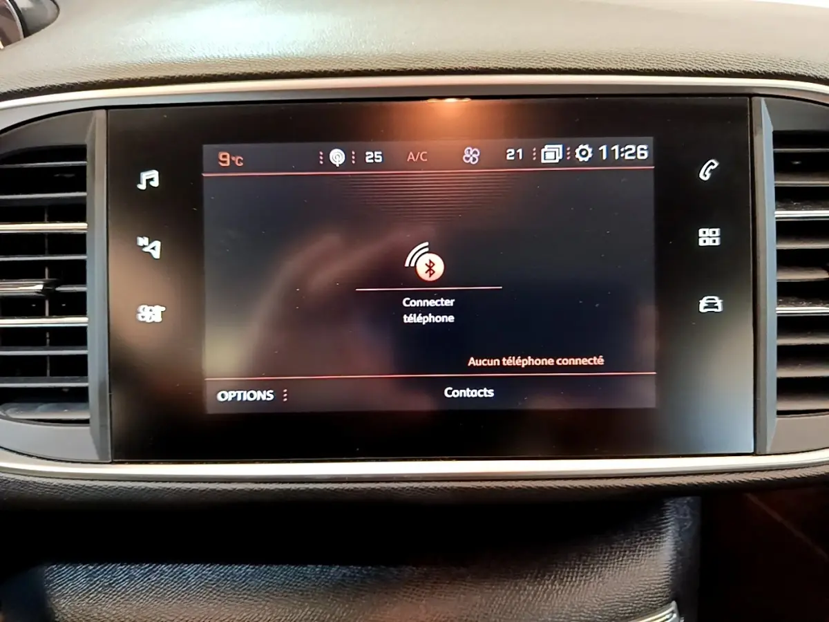 Écran tactile central de la Peugeot 308 2020 affichant la connexion Bluetooth pour téléphone, entouré de grilles d'aération.