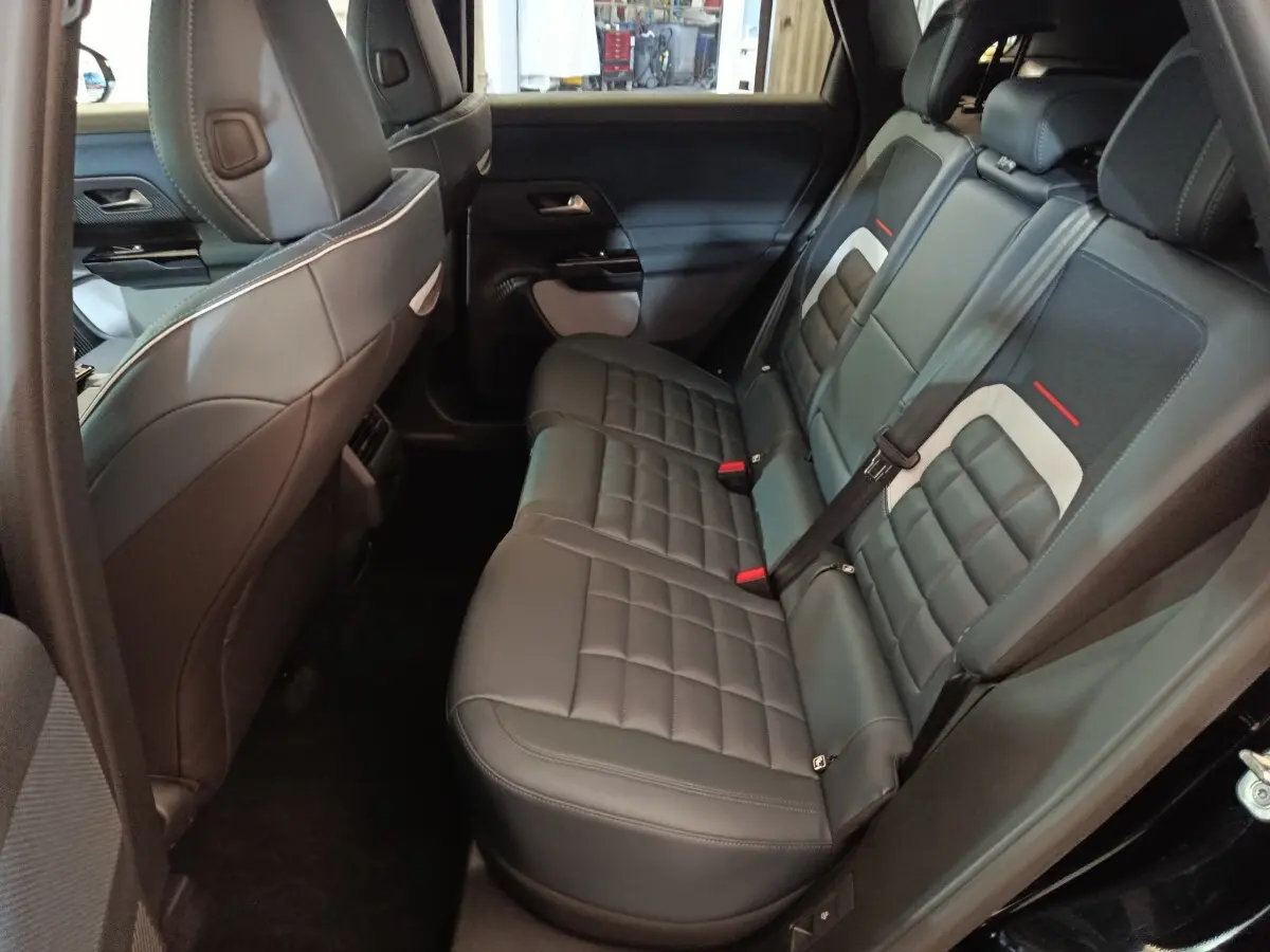 Vue intérieure côté droit des sièges arrière en cuir noir avec surpiqûres et détails gris et rouges du Citroën C5 Hybride 2026.