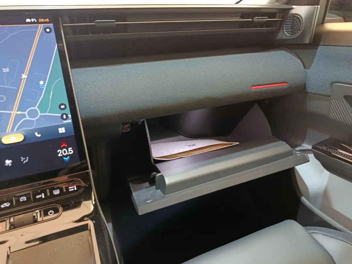 Intérieur de la Citroën C5 Hybride 2026, vue côté passager sur la boîte à gants ouverte et écran tactile central.