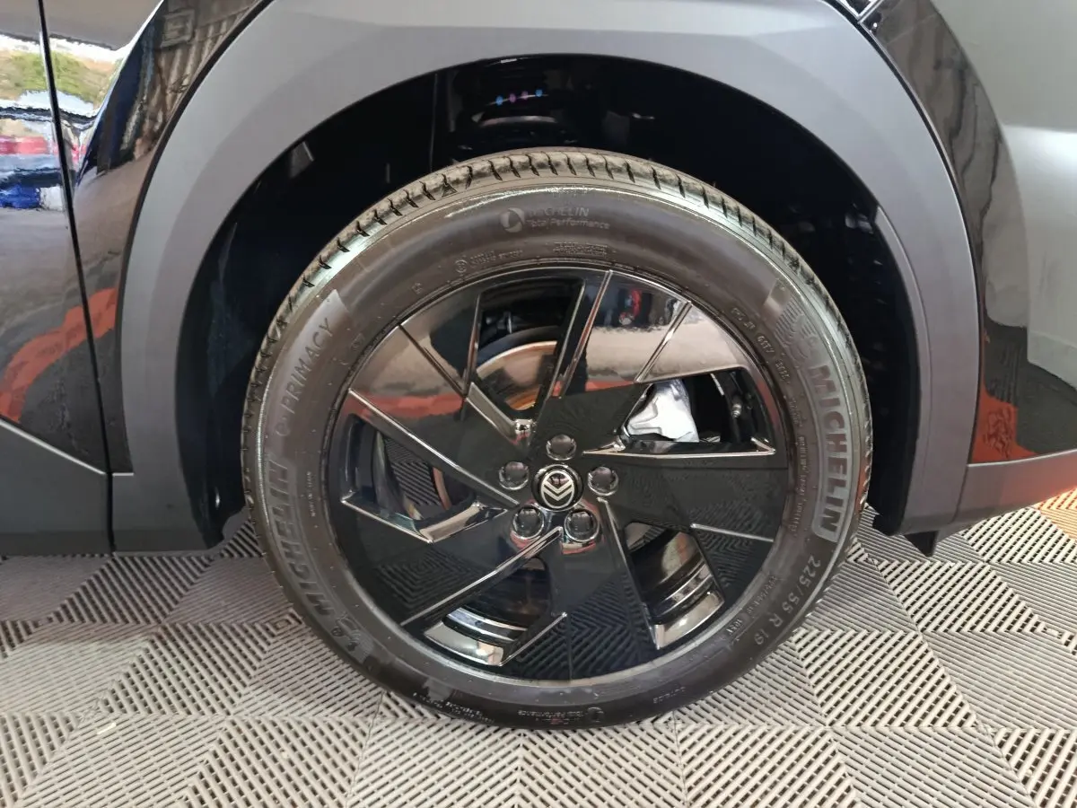 Gros plan sur la roue avant droite noire brillante du Citroën C5 Hybride 2026 avec jante au design moderne.