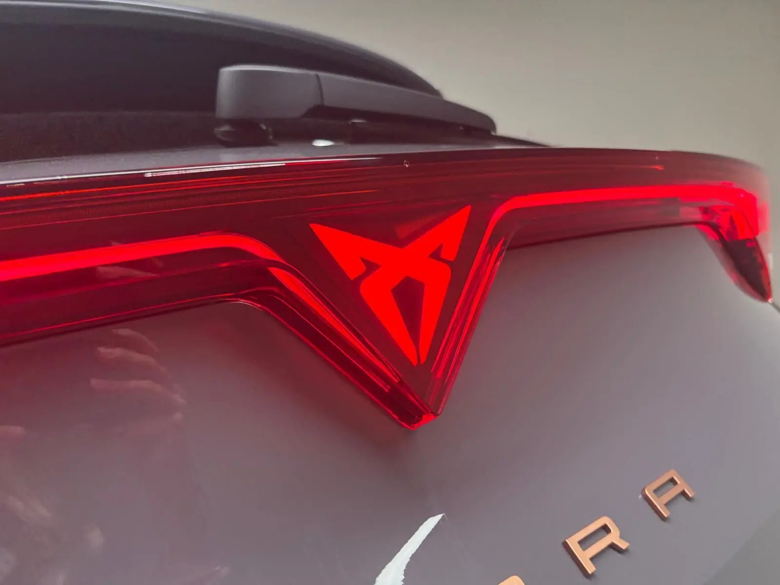 Gros plan sur le feu arrière rouge et le logo CUPRA d'un Formentor gris graphène 2025 avec toit ouvrant.