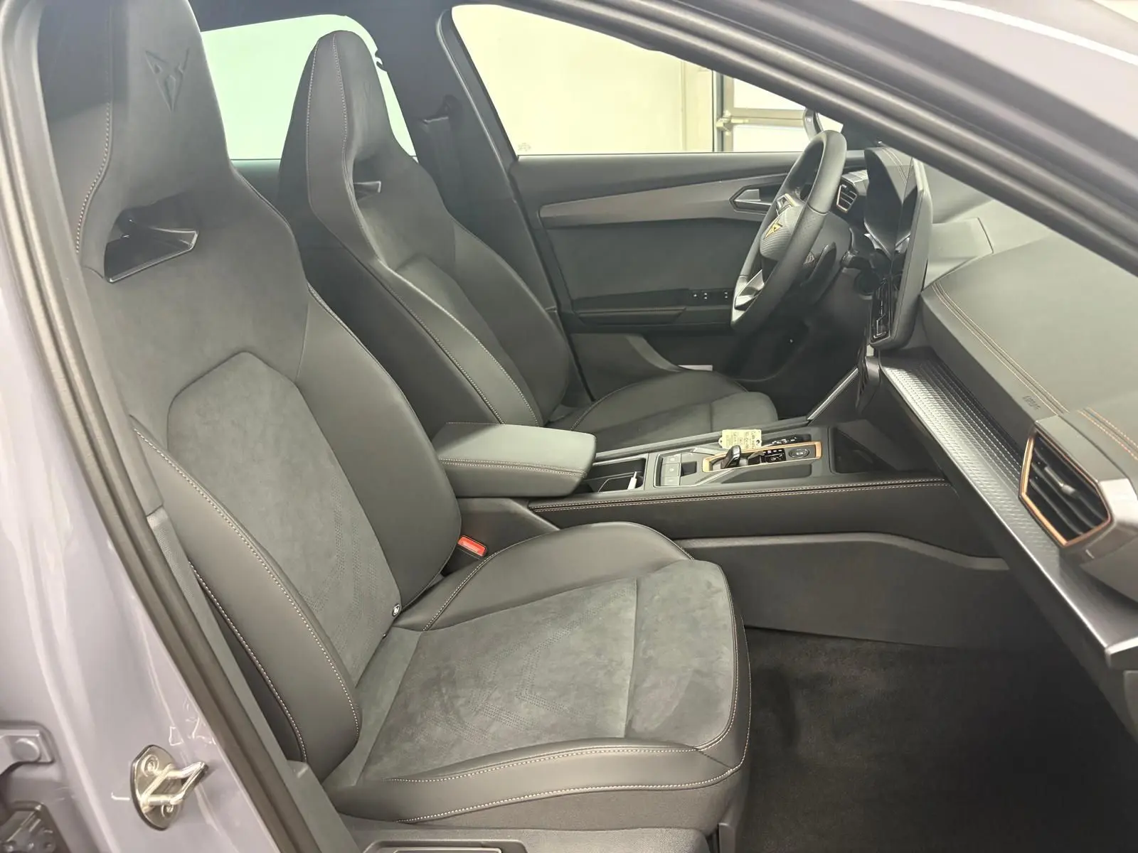 Intérieur côté conducteur du CUPRA Formentor 2025, sièges sport noirs avec surpiqûres contrastées et volant multifonction.