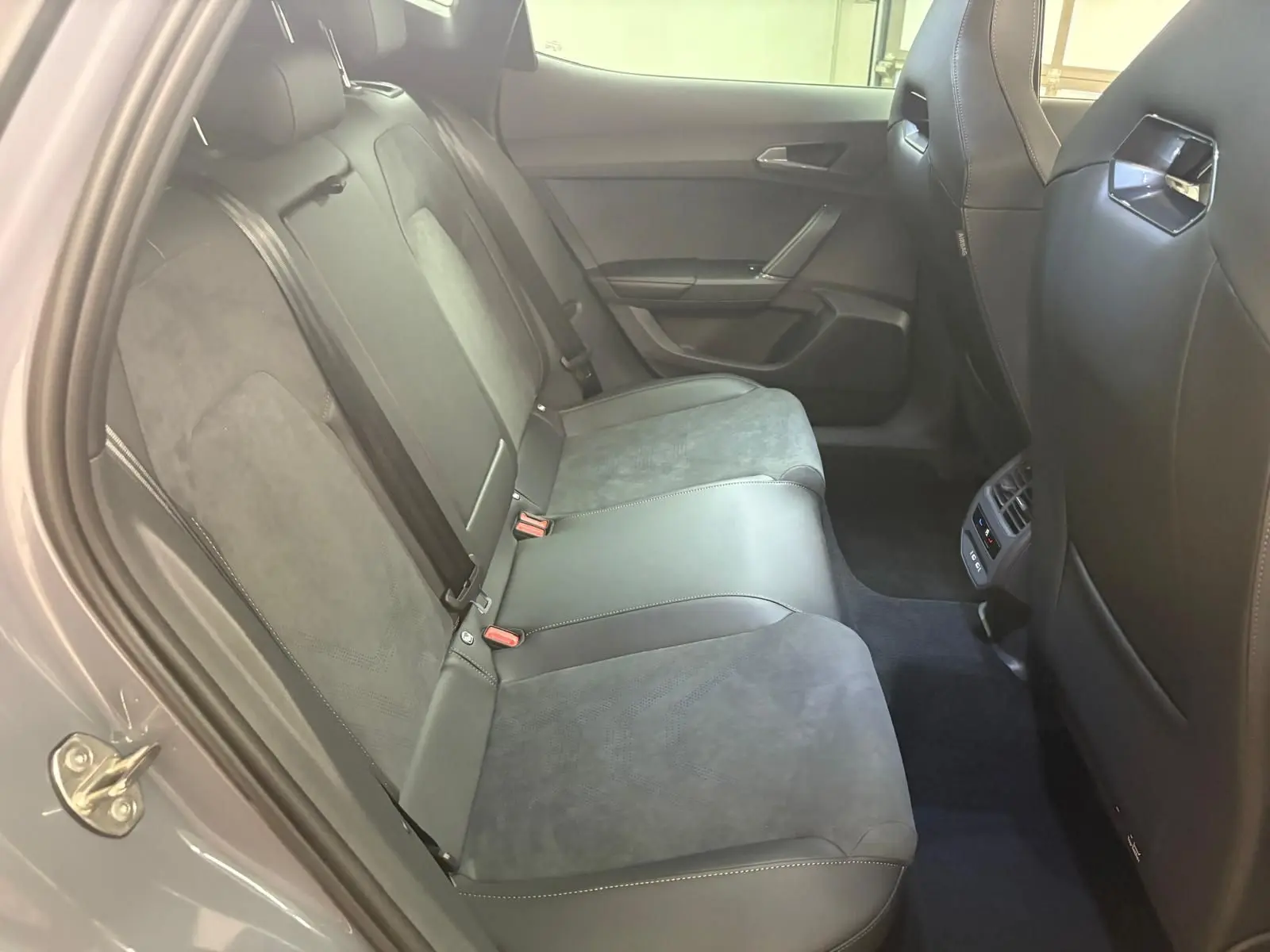 Banquette arrière en cuir et alcantara gris dans une CUPRA Formentor 2025, vue côté gauche avec porte ouverte.