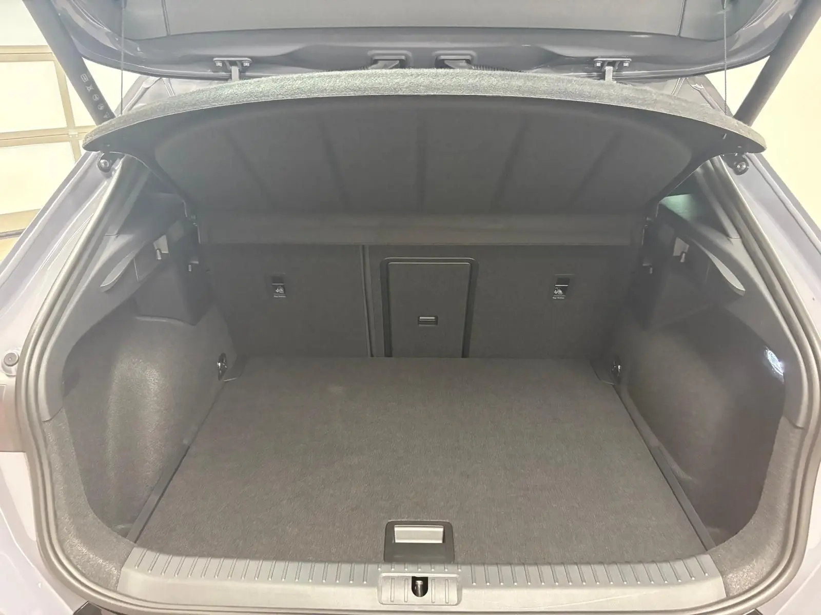 Coffre ouvert d'un CUPRA Formentor gris Graphène, vue arrière intérieure montrant un espace de chargement spacieux et bien fini.