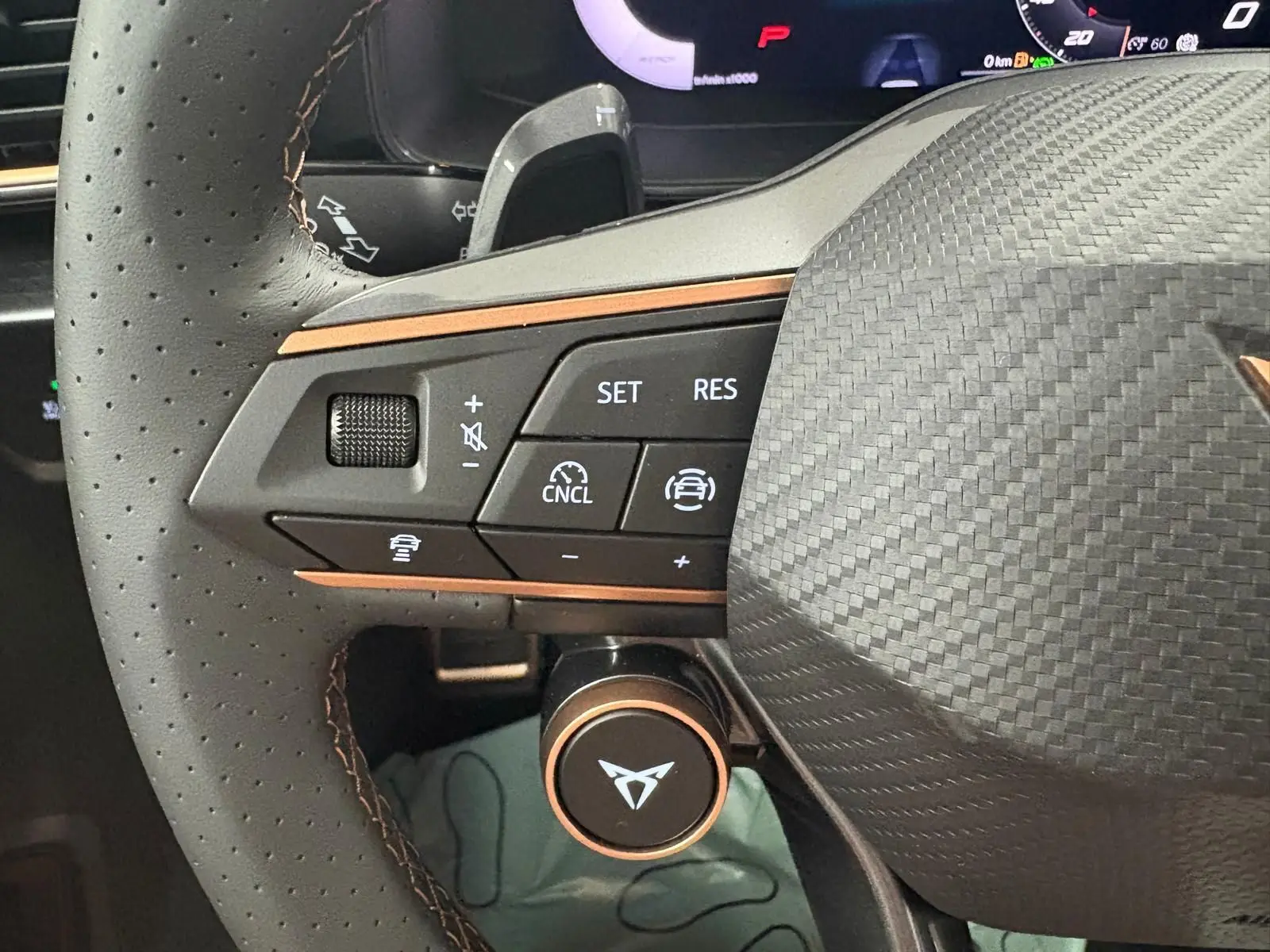 Gros plan sur le volant perforé du CUPRA Formentor 2025 avec commandes intégrées et logo cuivré distinctif.