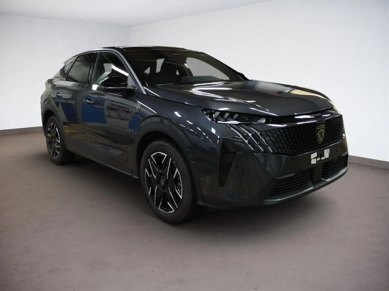 Peugeot 3008 Hybrid 145 GT gris Titane en 3/4 avant droit, avec calandre noire et jantes alliage noires.