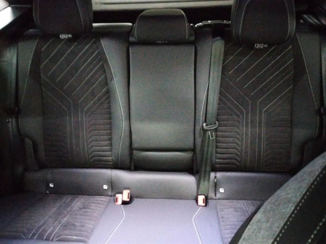 Vue de face des sièges arrière en Alcantara noir avec surpiqûres et motifs géométriques du Peugeot 3008 Hybrid GT 2025.